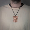 Model wearing copper shield pendant with chain