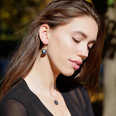 Woman wearing black argillite earrings & necklace